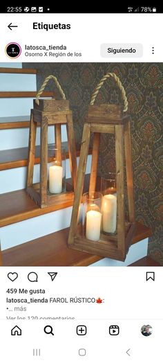 two wooden lanterns sitting on top of a stair case next to each other with candles in them