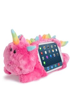 a pink stuffed animal laying next to an ipad