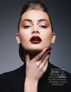 a woman with her hands on her face, wearing red lipstick and black dress shirt