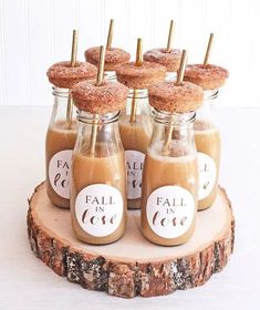 small jars filled with food sitting on top of a wooden slice covered in frosting