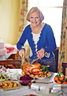 an older woman cutting a turkey on a table