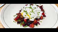 a white plate topped with fruit and whipped cream on top of it's side