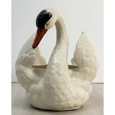 a white ceramic swan with a black beak