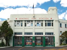 a large white building with green doors and windows on the top floor that says central fire station