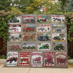 a quilt made to look like farmall tractors is displayed in front of a fence