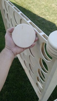 a person holding a frisbee in their hand near a wooden bench on the grass