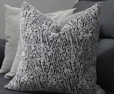 two pillows sitting on top of a gray couch