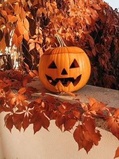 a carved pumpkin sitting on top of a cement wall