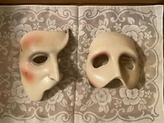 two white masks sitting on top of a table