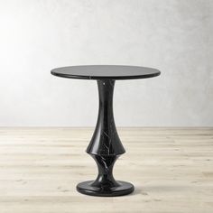 a black round table on a wooden floor