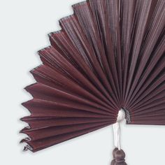 a close up of a red fan on a white background with an object in the foreground