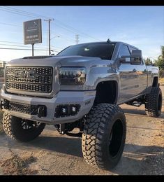 a silver truck parked on top of a dirt field