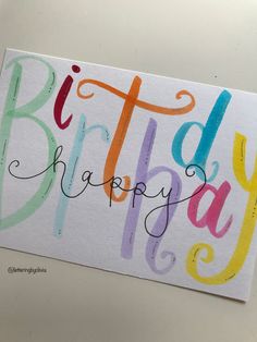 a birthday card with the words happy written in multicolored letters on white paper