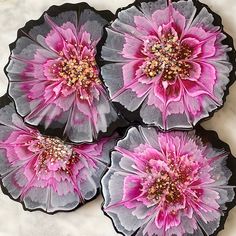 three pink and gray flowers on black trays