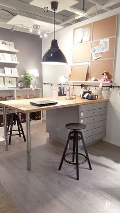 an office with two desks and stools in front of the work area is shown