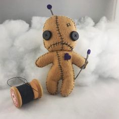 a voodoo doll next to a spool of thread