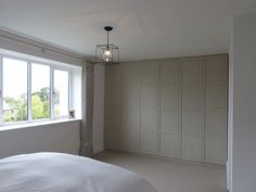 an empty bedroom with white walls and large windows