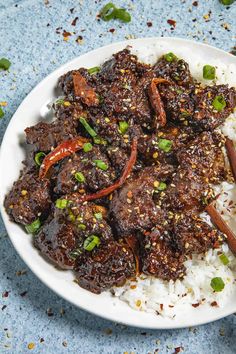 a white plate topped with meat and rice