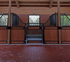 two horses are standing in their stalls at the stable