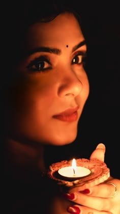 a woman holding a lit candle in her hand