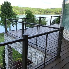 a wooden deck with metal railings next to a lake