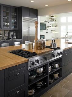 a kitchen with black cabinets and stainless steel appliances