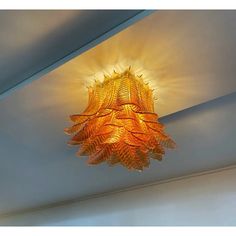 a chandelier hanging from the ceiling in a room with light coming through it