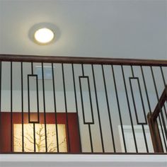 a light that is on in the ceiling above a balcony rail and railing with an open door