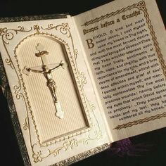 an open book with a crucifix on it