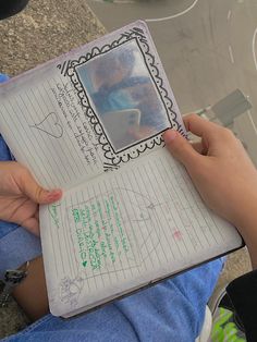 a person holding a notebook with writing on it