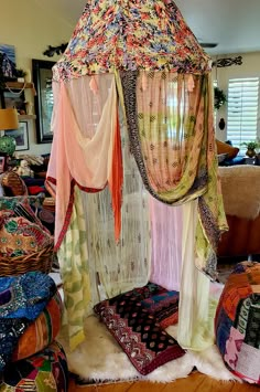 a canopy bed covered in colorful fabrics and curtains