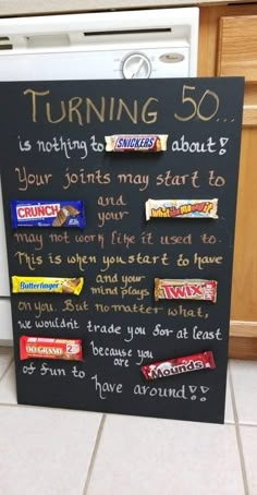 a chalk board with candy bars written on it in front of a dishwasher