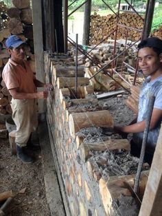 two men standing next to each other near logs