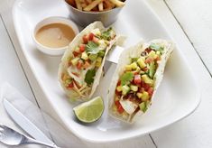 two tacos and some fries on a white plate