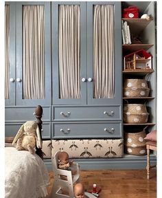 a child's bedroom with blue cabinets and toys