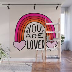 a wall mural with the words you are loved in rainbows and hearts on it