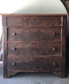 an old wooden dresser with a mirror on top