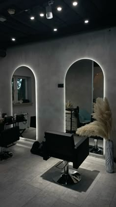 a hair salon with chairs, mirrors and lights