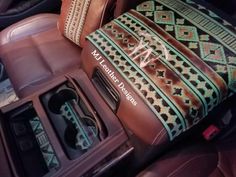 the interior of a car with leather seats and decorative pillows