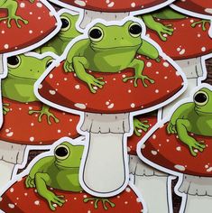 frog stickers sitting on top of red mushrooms with white dots and green toadies