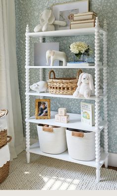 a white shelf with baskets and stuffed animals on it