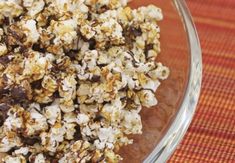 a glass bowl filled with popcorn on top of a table