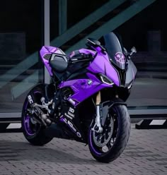 a purple motorcycle parked in front of a building