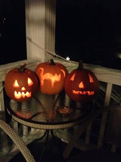 three carved pumpkins sitting on top of a table