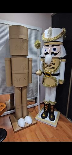 a cardboard nutcracker standing next to an egg carton