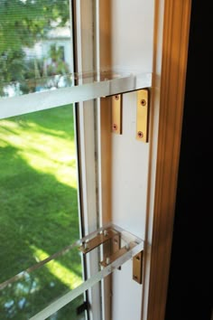 two glass shelves on the side of a window in front of a green lawn outside