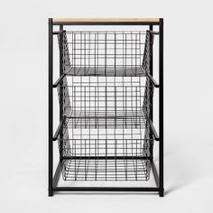 an iron and wood shelf with wire baskets on the top, against a white background