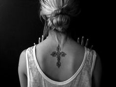 a woman with a cross tattoo on her back