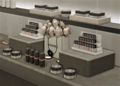 a counter with cosmetics and other items on it in a store window display, along with candles