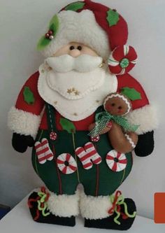 a santa clause holding a teddy bear on top of a table